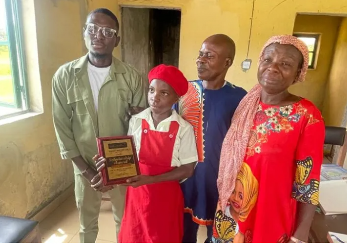 Corps member awards a scholarship to a student from his allowance